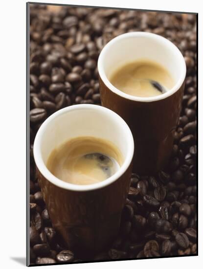Two Espressos Standing on Coffee Beans-null-Mounted Photographic Print