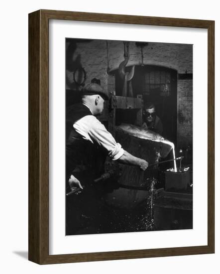 Two Factory Workers Pour Molten Metal into a Small Mould. Photograph by Heinz Zinram-Heinz Zinram-Framed Photographic Print