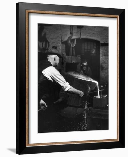 Two Factory Workers Pour Molten Metal into a Small Mould. Photograph by Heinz Zinram-Heinz Zinram-Framed Photographic Print