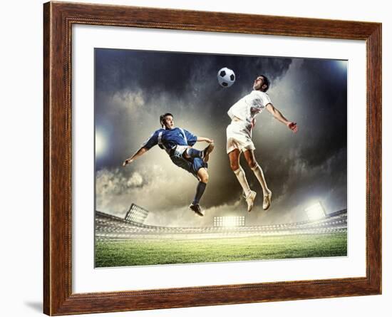 Two Football Players in Jump to Strike the Ball at the Stadium-Sergey Nivens-Framed Photographic Print