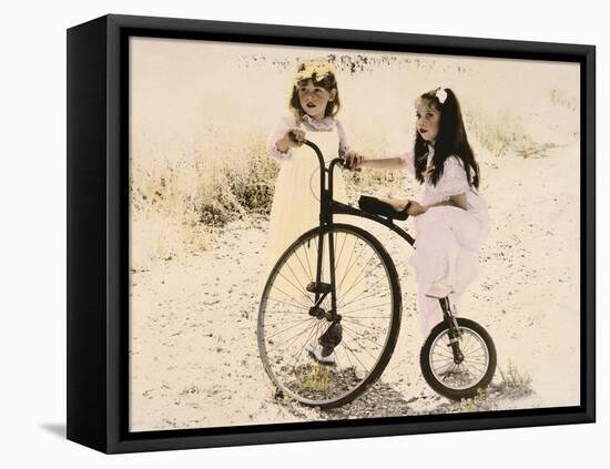 Two Little Girls by an Old Fashioned Bicycle-Nora Hernandez-Framed Premier Image Canvas