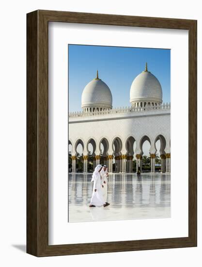 Two Middle Eastern men traditionally dressed walking in the courtyard of the Sheikh Zayed Mosque, A-Stefano Politi Markovina-Framed Photographic Print