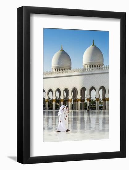 Two Middle Eastern men traditionally dressed walking in the courtyard of the Sheikh Zayed Mosque, A-Stefano Politi Markovina-Framed Photographic Print