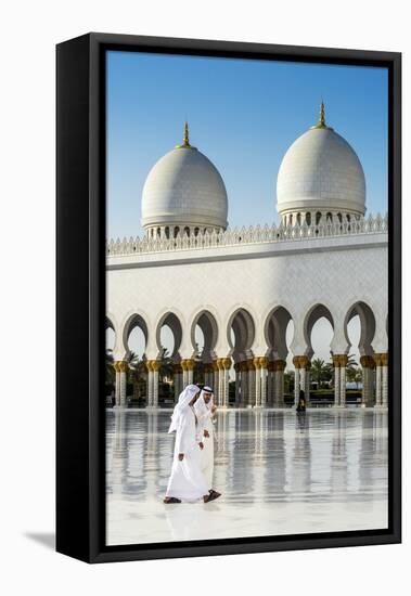 Two Middle Eastern men traditionally dressed walking in the courtyard of the Sheikh Zayed Mosque, A-Stefano Politi Markovina-Framed Premier Image Canvas