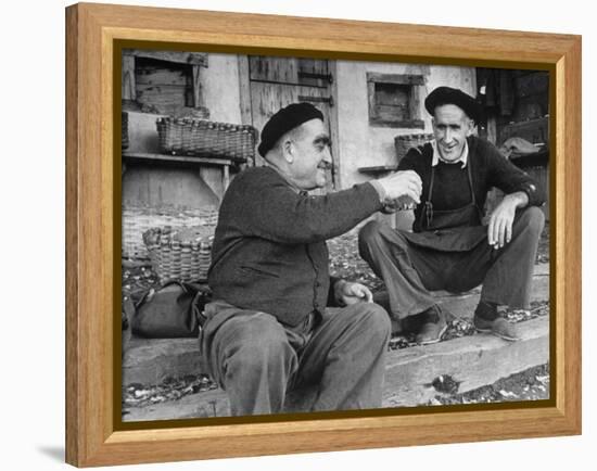 Two Older Basque Men Sitting on a Porch Toasting, as They Prepare to Drink Together-Dmitri Kessel-Framed Premier Image Canvas