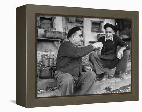 Two Older Basque Men Sitting on a Porch Toasting, as They Prepare to Drink Together-Dmitri Kessel-Framed Premier Image Canvas