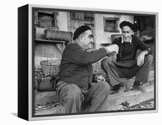 Two Older Basque Men Sitting on a Porch Toasting, as They Prepare to Drink Together-Dmitri Kessel-Framed Premier Image Canvas