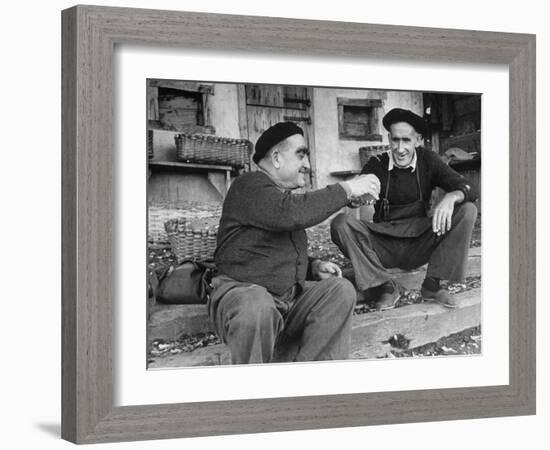 Two Older Basque Men Sitting on a Porch Toasting, as They Prepare to Drink Together-Dmitri Kessel-Framed Photographic Print