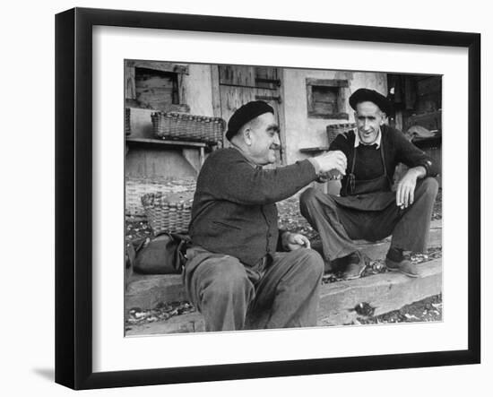 Two Older Basque Men Sitting on a Porch Toasting, as They Prepare to Drink Together-Dmitri Kessel-Framed Photographic Print