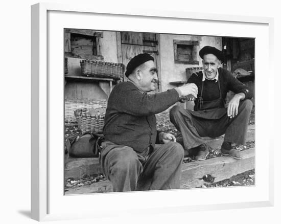 Two Older Basque Men Sitting on a Porch Toasting, as They Prepare to Drink Together-Dmitri Kessel-Framed Photographic Print