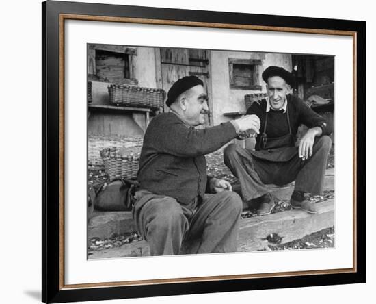 Two Older Basque Men Sitting on a Porch Toasting, as They Prepare to Drink Together-Dmitri Kessel-Framed Photographic Print