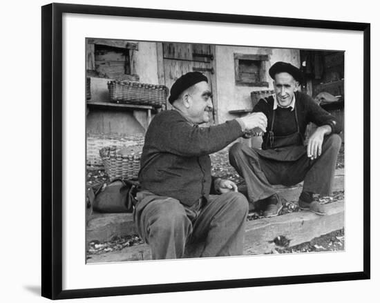 Two Older Basque Men Sitting on a Porch Toasting, as They Prepare to Drink Together-Dmitri Kessel-Framed Photographic Print