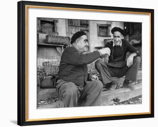 Two Older Basque Men Sitting on a Porch Toasting, as They Prepare to Drink Together-Dmitri Kessel-Framed Photographic Print