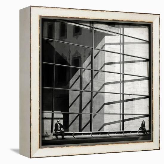 Two People Sitting Outside a Modern Glass Building-Eudald Castells-Framed Premier Image Canvas