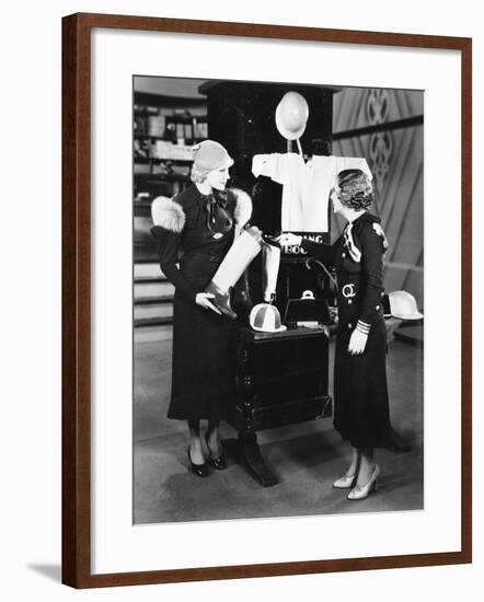 Two Women in a Store Looking at the Display-null-Framed Photo