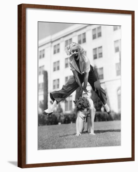 Two Women Playing Leap Frog Together-null-Framed Photo