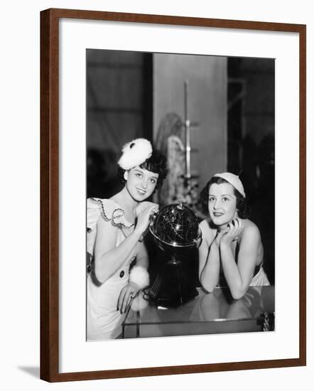 Two Women Posing Next to a Globe-null-Framed Photo