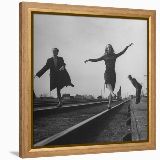 Two Young Ballet Russe Dancers Balancing on the Railroad Tracks in the Station While on Tour-Myron Davis-Framed Premier Image Canvas