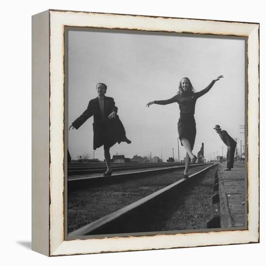 Two Young Ballet Russe Dancers Balancing on the Railroad Tracks in the Station While on Tour-Myron Davis-Framed Premier Image Canvas