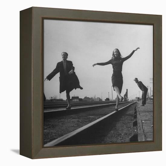 Two Young Ballet Russe Dancers Balancing on the Railroad Tracks in the Station While on Tour-Myron Davis-Framed Premier Image Canvas