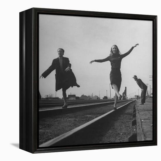 Two Young Ballet Russe Dancers Balancing on the Railroad Tracks in the Station While on Tour-Myron Davis-Framed Premier Image Canvas