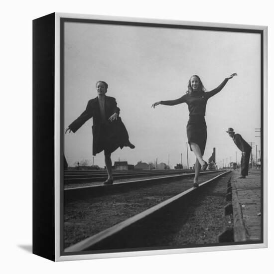 Two Young Ballet Russe Dancers Balancing on the Railroad Tracks in the Station While on Tour-Myron Davis-Framed Premier Image Canvas