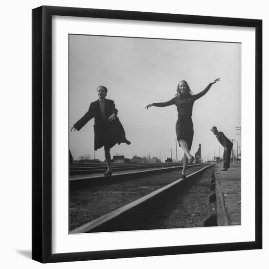 Two Young Ballet Russe Dancers Balancing on the Railroad Tracks in the Station While on Tour-Myron Davis-Framed Photographic Print