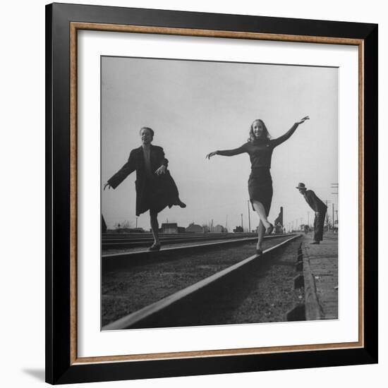 Two Young Ballet Russe Dancers Balancing on the Railroad Tracks in the Station While on Tour-Myron Davis-Framed Photographic Print