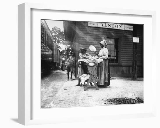 Two Young Black Women Selling Cakes at Alston Railroad Station, Next to a Train That Has Stopped-Wallace G^ Levison-Framed Photographic Print