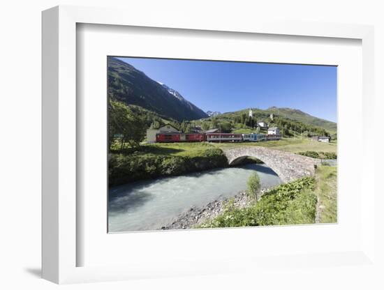 Typical red Swiss train on Hospental Viadukt surrounded by creek and green meadows, Andermatt, Cant-Roberto Moiola-Framed Photographic Print