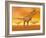 Tyrannosaurus Rex Dinosaurs in an Orange Foggy Desert by Sunset-null-Framed Art Print