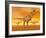 Tyrannosaurus Rex Dinosaurs in an Orange Foggy Desert by Sunset-null-Framed Art Print