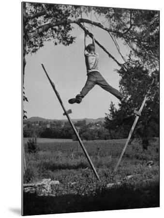 Kenneth Merriman Swinging on Tree Limb after Kicking Away 
