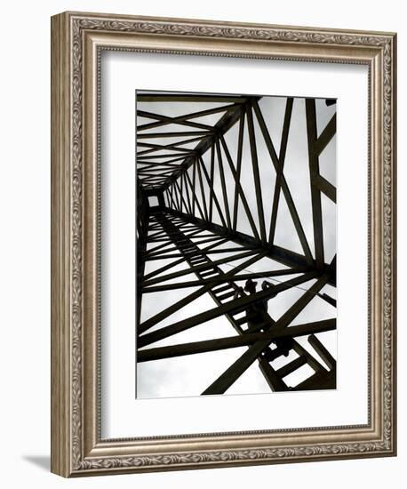 A Reenactor is Silhouetted Inside a Replica of the Spindletop Oil Derrick-null-Framed Photographic Print