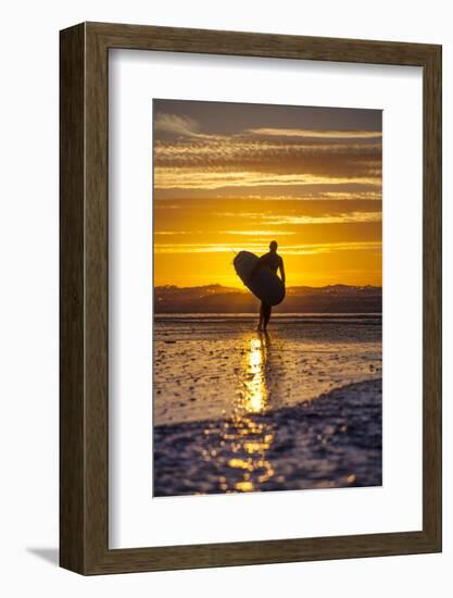 Uk, Cornwall, Polzeath. a Woman Comes in from an Evening Surf Against a Stunning Sunset.-Niels Van Gijn-Framed Photographic Print