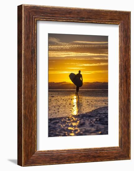 Uk, Cornwall, Polzeath. a Woman Comes in from an Evening Surf Against a Stunning Sunset.-Niels Van Gijn-Framed Photographic Print