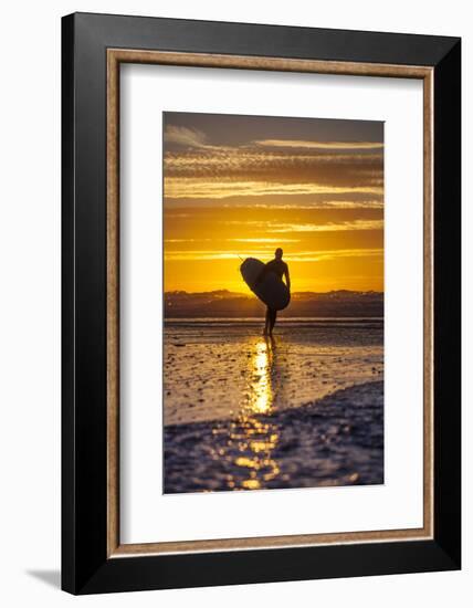 Uk, Cornwall, Polzeath. a Woman Comes in from an Evening Surf Against a Stunning Sunset.-Niels Van Gijn-Framed Photographic Print