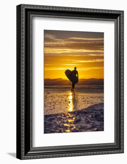Uk, Cornwall, Polzeath. a Woman Comes in from an Evening Surf Against a Stunning Sunset.-Niels Van Gijn-Framed Photographic Print