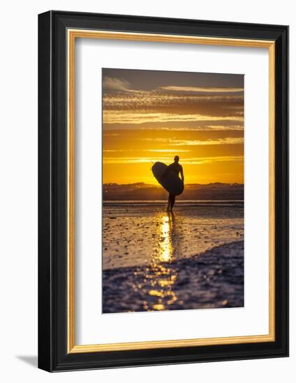Uk, Cornwall, Polzeath. a Woman Comes in from an Evening Surf Against a Stunning Sunset.-Niels Van Gijn-Framed Photographic Print