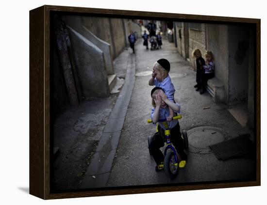 Ultra-Orthodox Jewish Children Cover their Faces as They Play in a Street in Jerusalem-null-Framed Premier Image Canvas