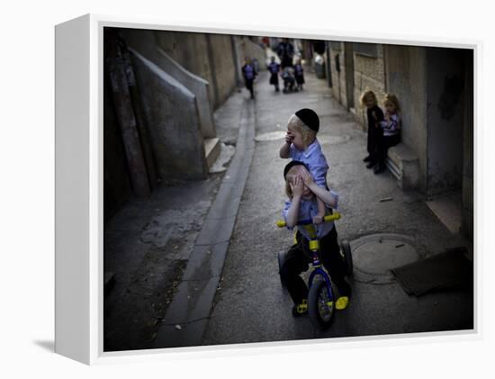 Ultra-Orthodox Jewish Children Cover their Faces as They Play in a Street in Jerusalem-null-Framed Premier Image Canvas