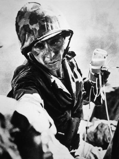 us marine medic drips blood plasma into a wounded comrade saipan