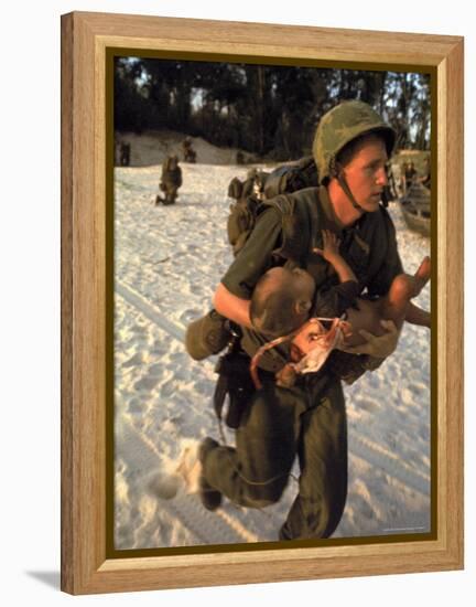 US Marine Medic Running Along Beach with Injured Vietnamese Infant under Fire During Vietnam War-Paul Schutzer-Framed Premier Image Canvas
