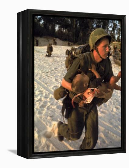 US Marine Medic Running Along Beach with Injured Vietnamese Infant under Fire During Vietnam War-Paul Schutzer-Framed Premier Image Canvas