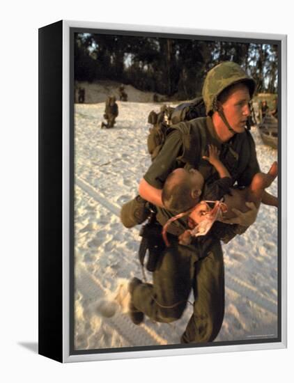 US Marine Medic Running Along Beach with Injured Vietnamese Infant under Fire During Vietnam War-Paul Schutzer-Framed Premier Image Canvas