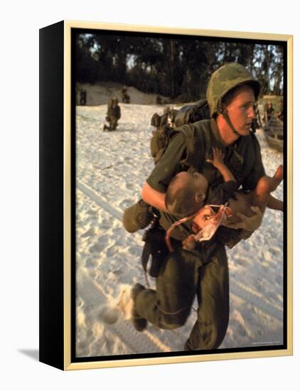 US Marine Medic Running Along Beach with Injured Vietnamese Infant under Fire During Vietnam War-Paul Schutzer-Framed Premier Image Canvas