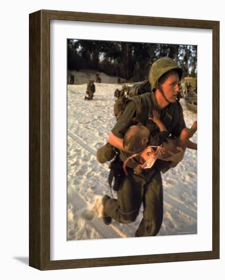 US Marine Medic Running Along Beach with Injured Vietnamese Infant under Fire During Vietnam War-Paul Schutzer-Framed Photographic Print