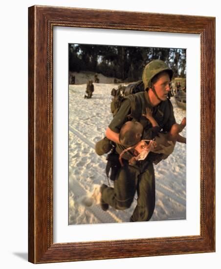 US Marine Medic Running Along Beach with Injured Vietnamese Infant under Fire During Vietnam War-Paul Schutzer-Framed Photographic Print