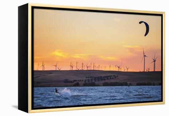 Usa, California, Rio Vista. Kiteboarder at sunset with wind farm turbines.-Merrill Images-Framed Premier Image Canvas