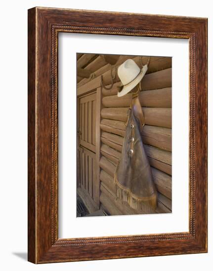 USA, Montana, Livingston, cowboy hat and chaps hanging on barn wall.-Merrill Images-Framed Photographic Print